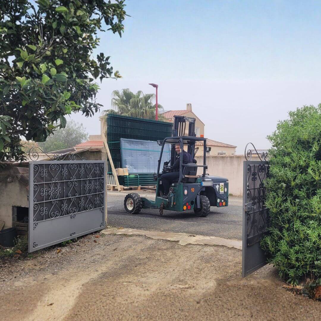 Manutention Cargomatic : déchargement précis avec chariot embarqué dans une cour de maison individuelle en France