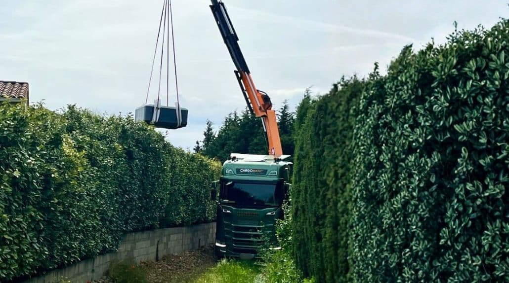 Livraison d'un spa par dessus une haie grâce à un camion grue Cargomatic